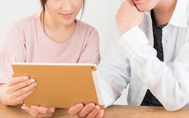 タブレットを見る夫婦・画像